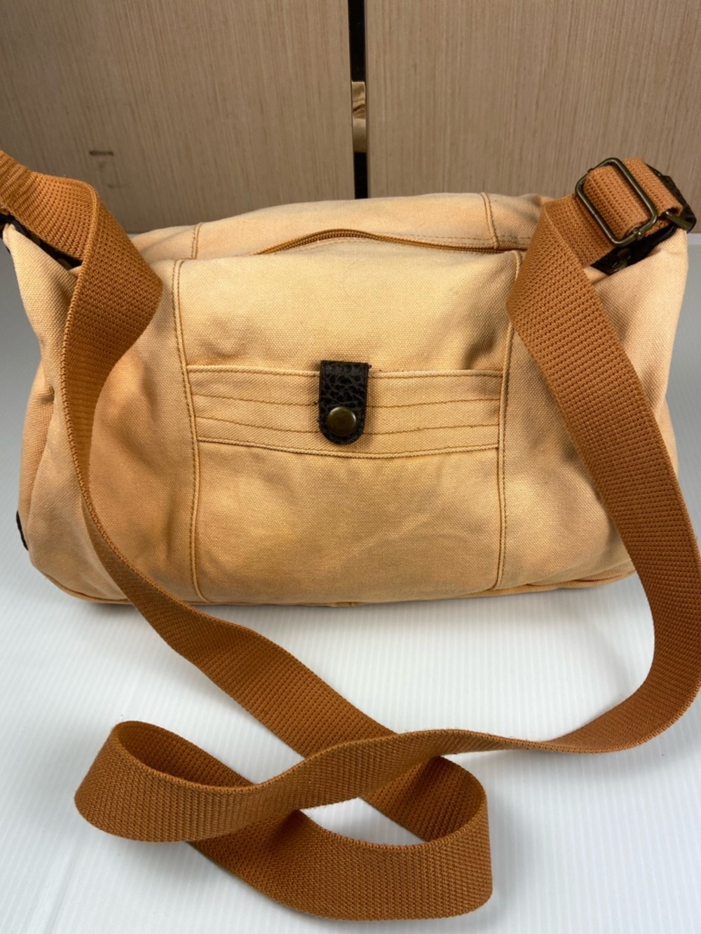 Driftwood canvas crossbody bag in a soft peach tone with leather accents